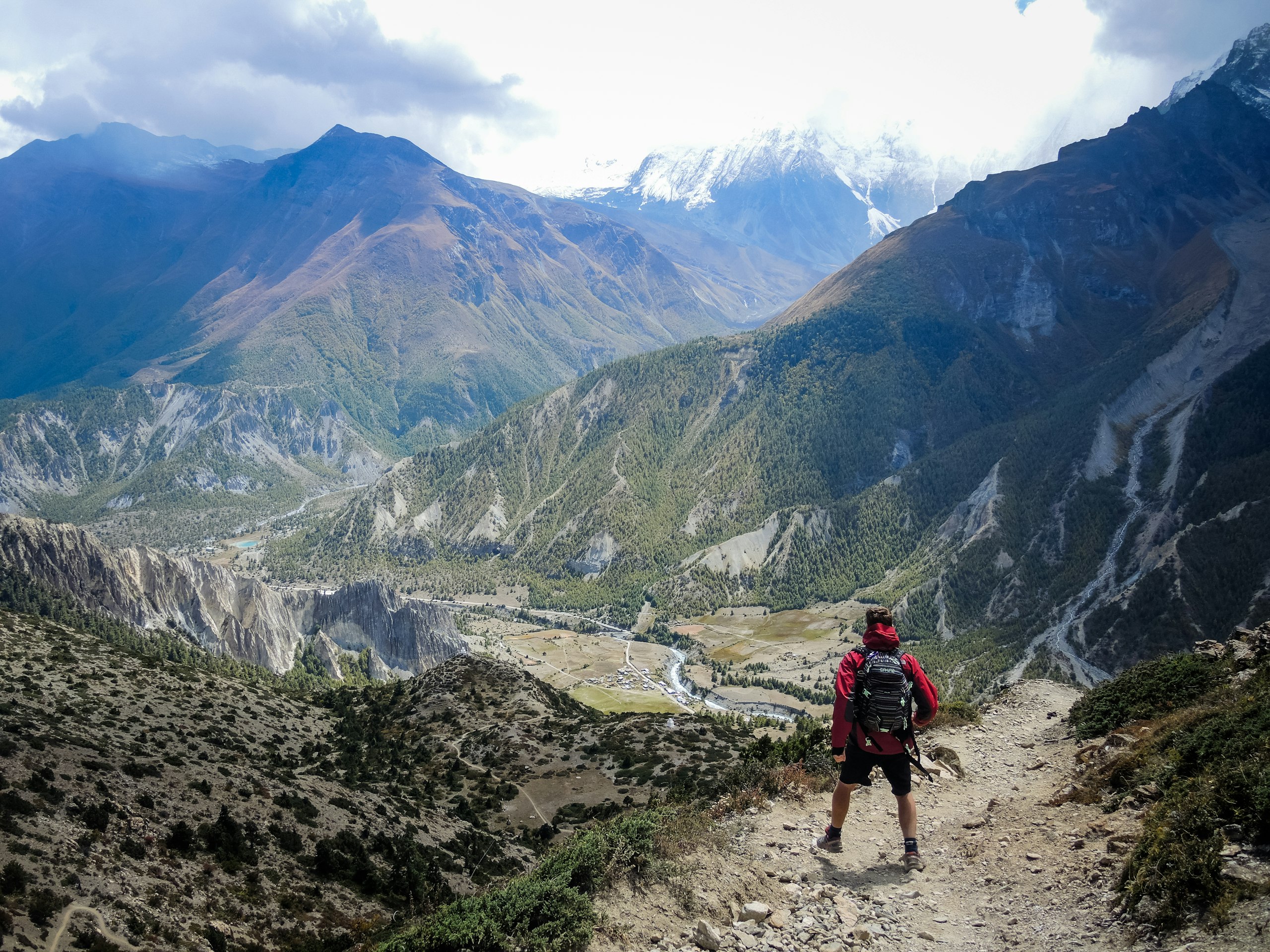 A lone trekker on a quiet winding mountain trail in the Nepal Himalaya