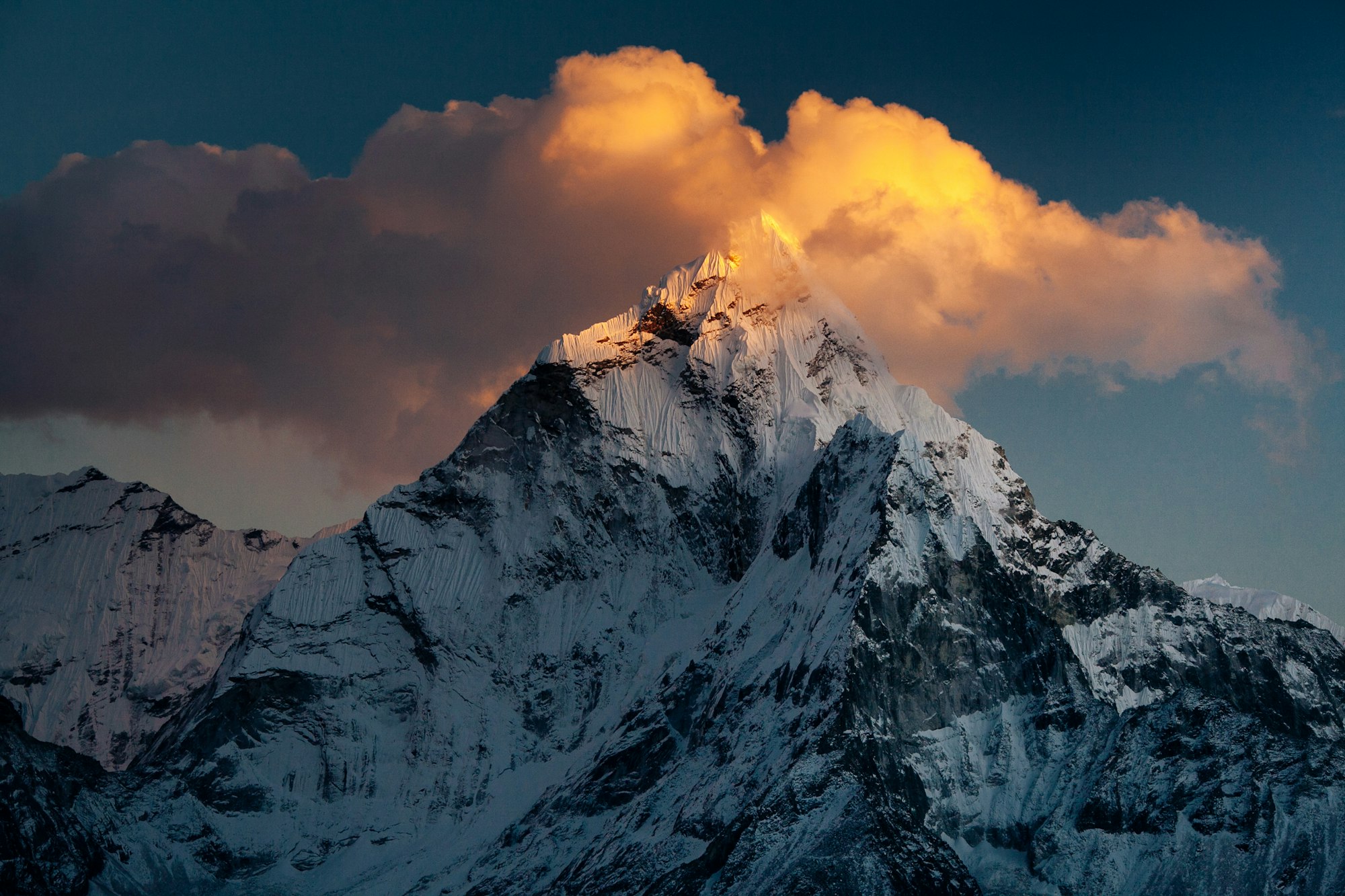 Ama Dablam's summit catching golden sunset light through cloud, Khumbu, Sagarmatha National Park, Nepal
