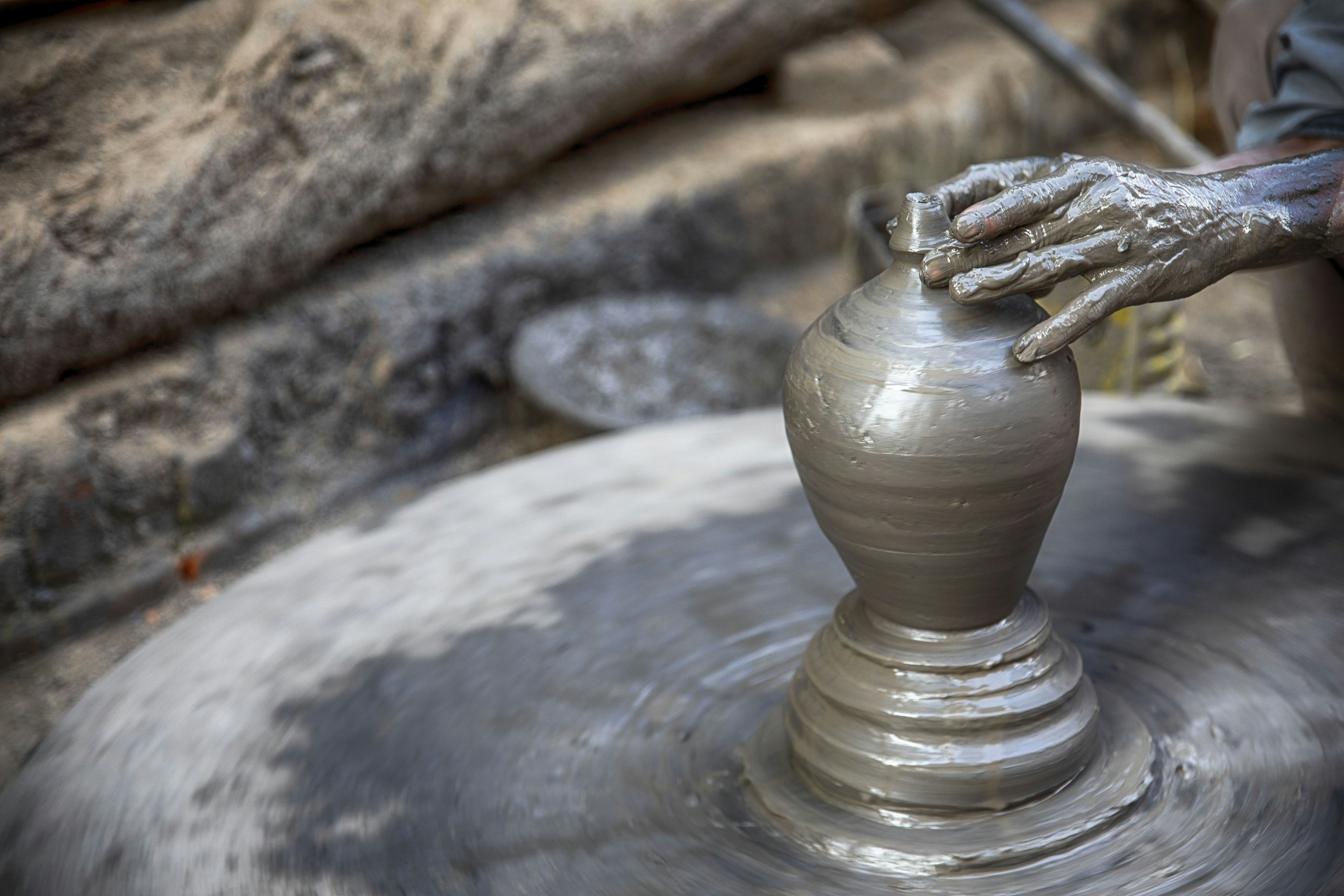 A potter’s hands shaping wet clay on a spinning wheel in Bhaktapur, Nepal