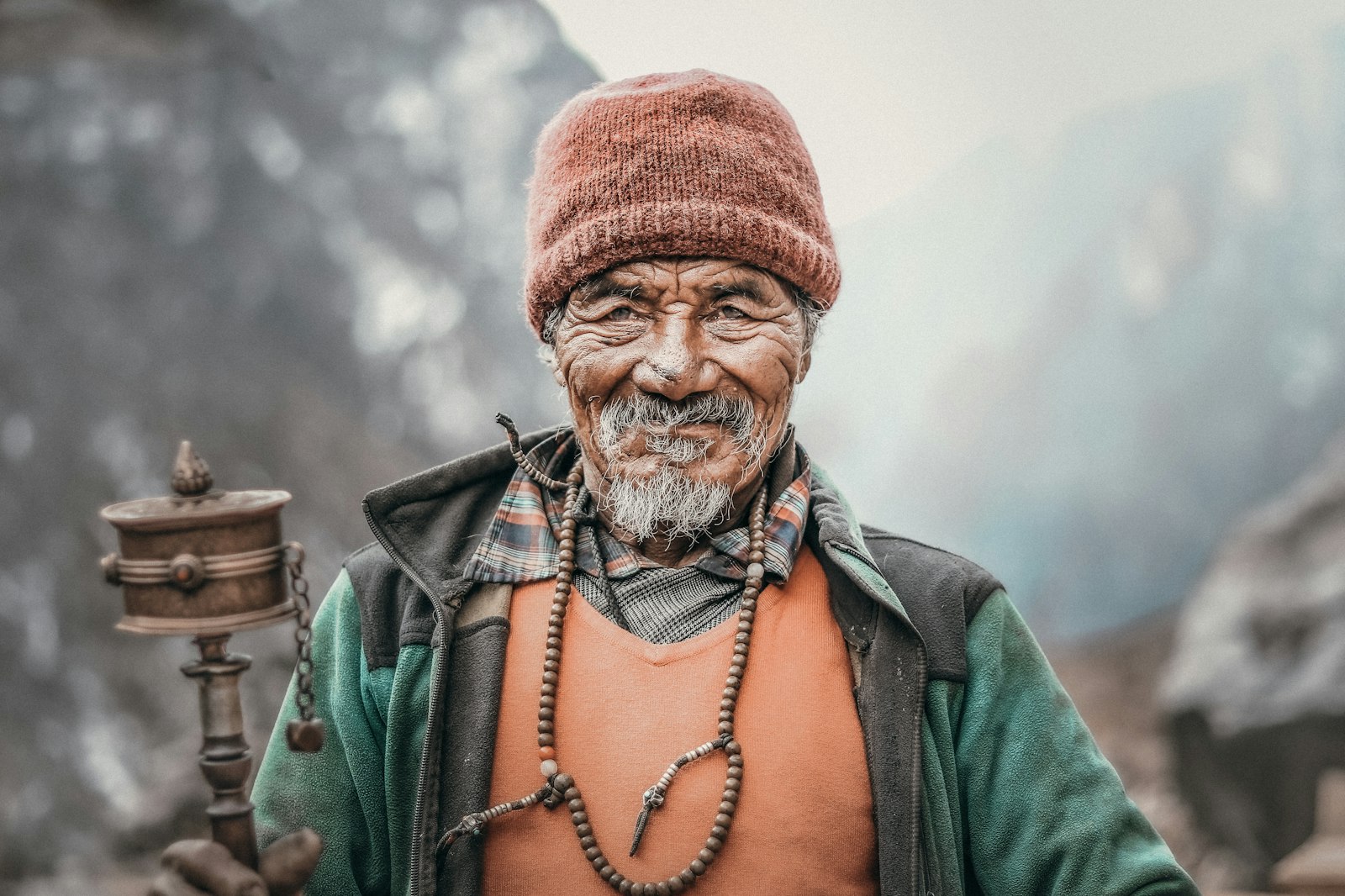 Portrait of a Tamang man in a knit cap in a Nepali mountain village setting