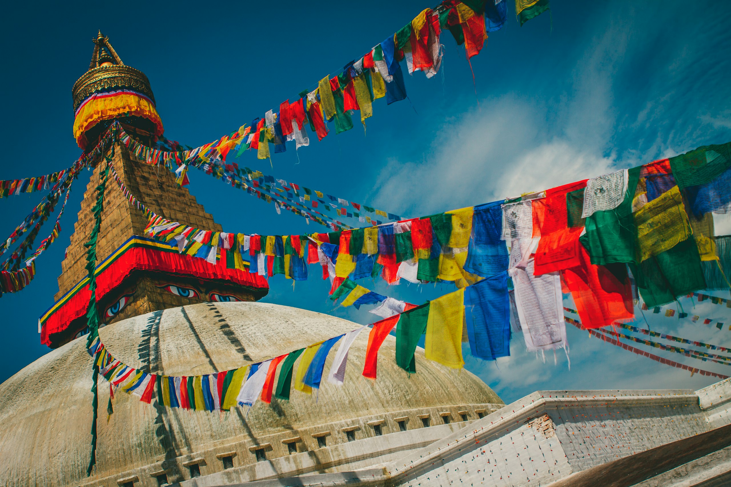 Boudhanath Stupa with prayer flags rising over the Kathmandu Valley, Nepal