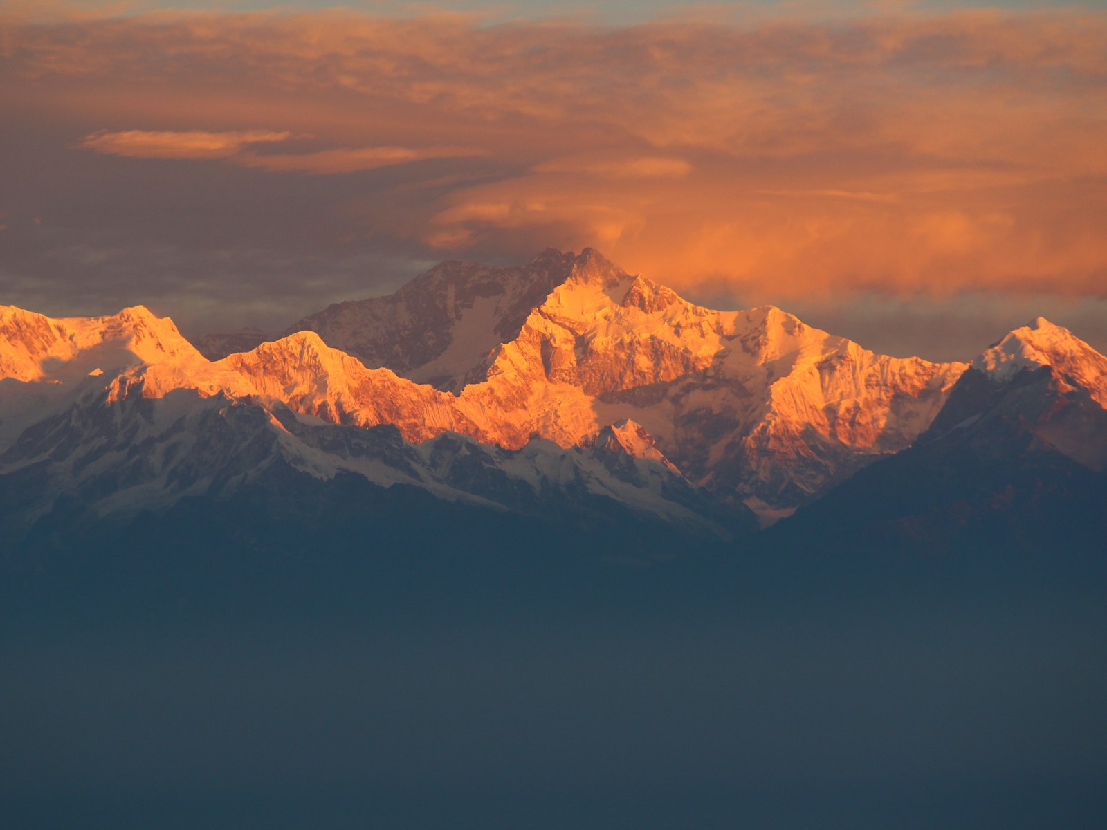 Golden sunrise alpenglow lighting the snow-covered Kanchenjunga massif in remote eastern Nepal